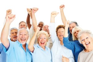 Group of happy senior citizens with their hands raised over white